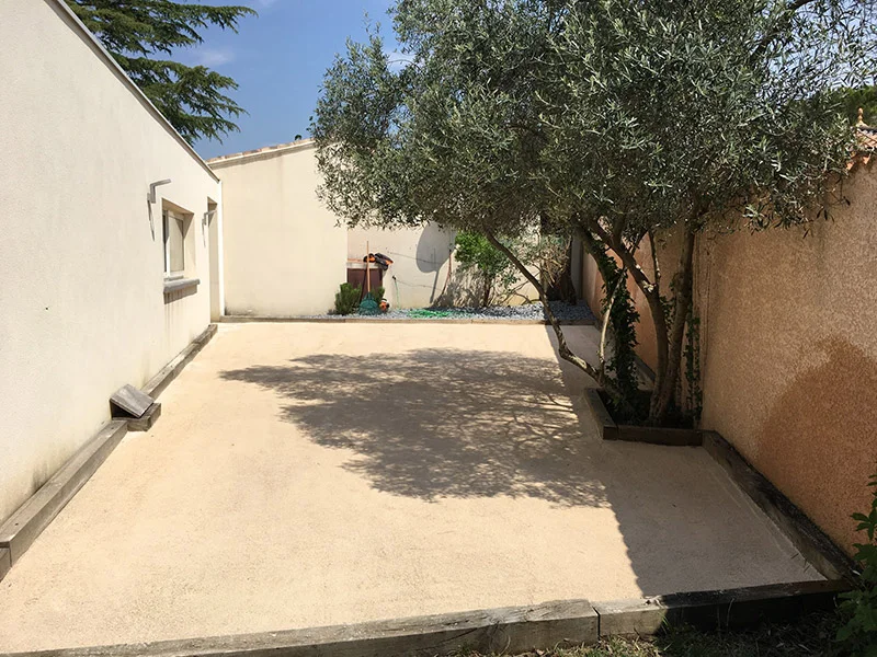 Aménagement d’une cour minérale autour d’un olivier — Paysagiste — par Altea Paysages — à Saint-Hilaire-de-Beauvoir